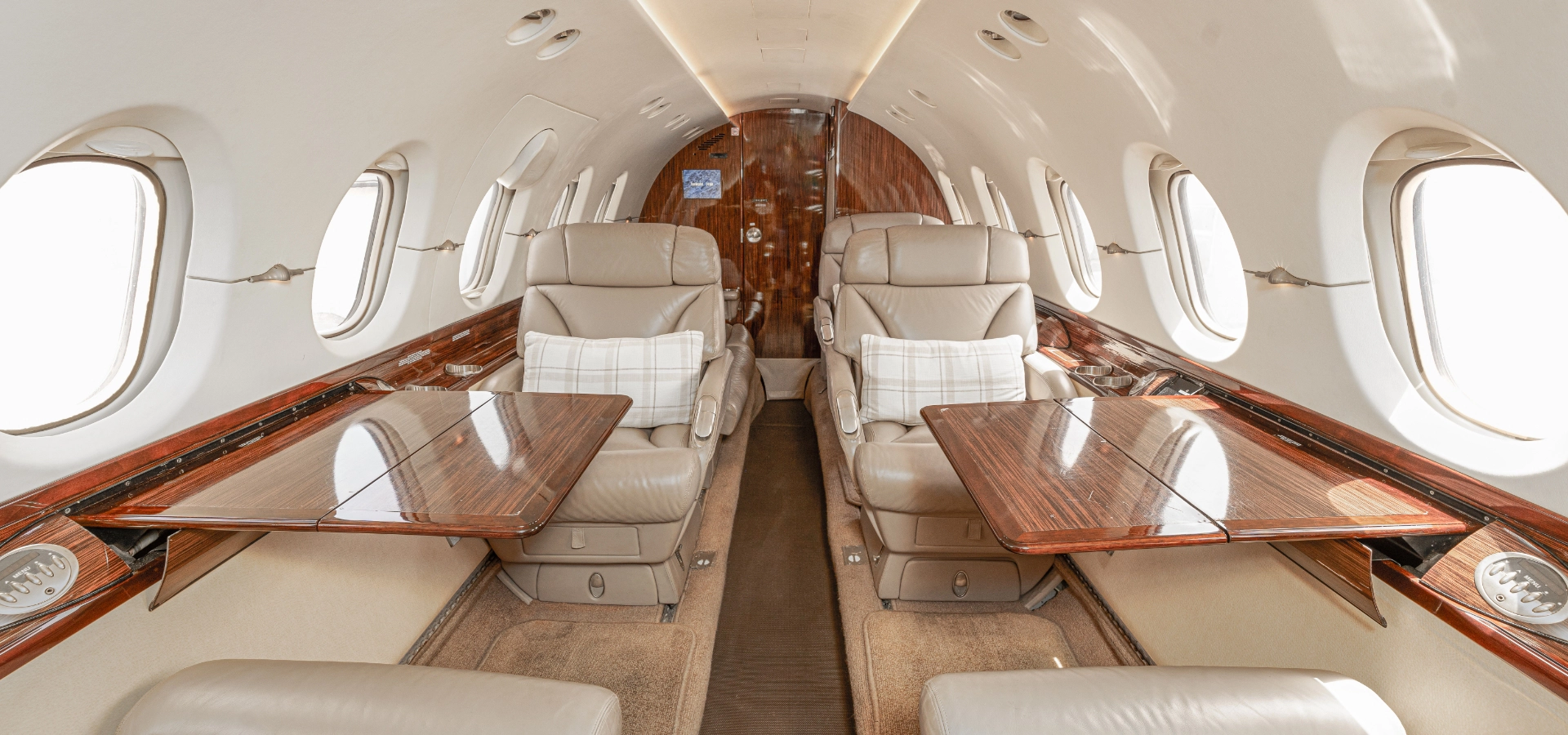 The interior of the 2000 Hawker 800XP SN 258468 features four luxurious leather seats, complemented by elegant wooden fold-out tables and expansive windows, creating a sophisticated atmosphere for private travel.