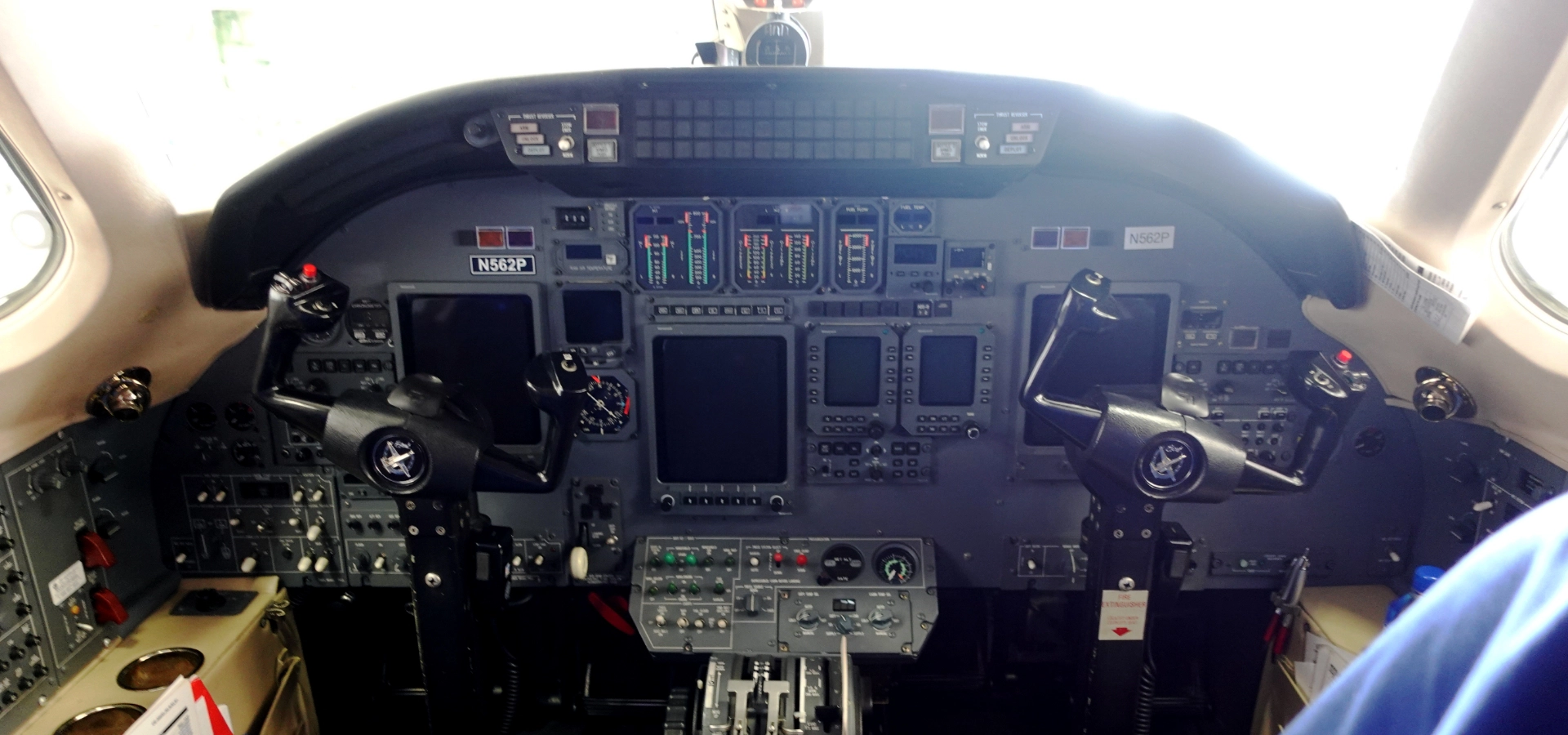 The cockpit of an aircraft reveals a realm of aviation consulting services, showcasing control panels, dual yokes, various switches, and digital displays.