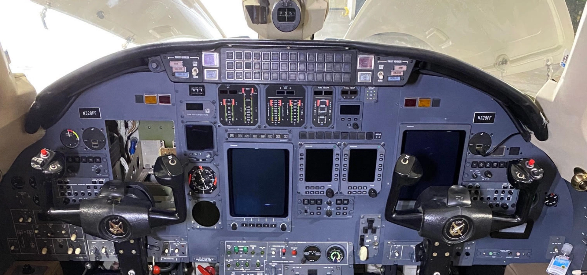 The cockpit interior of an aircraft features a range of controls, switches, and displays, with dual control yokes prominently visible.