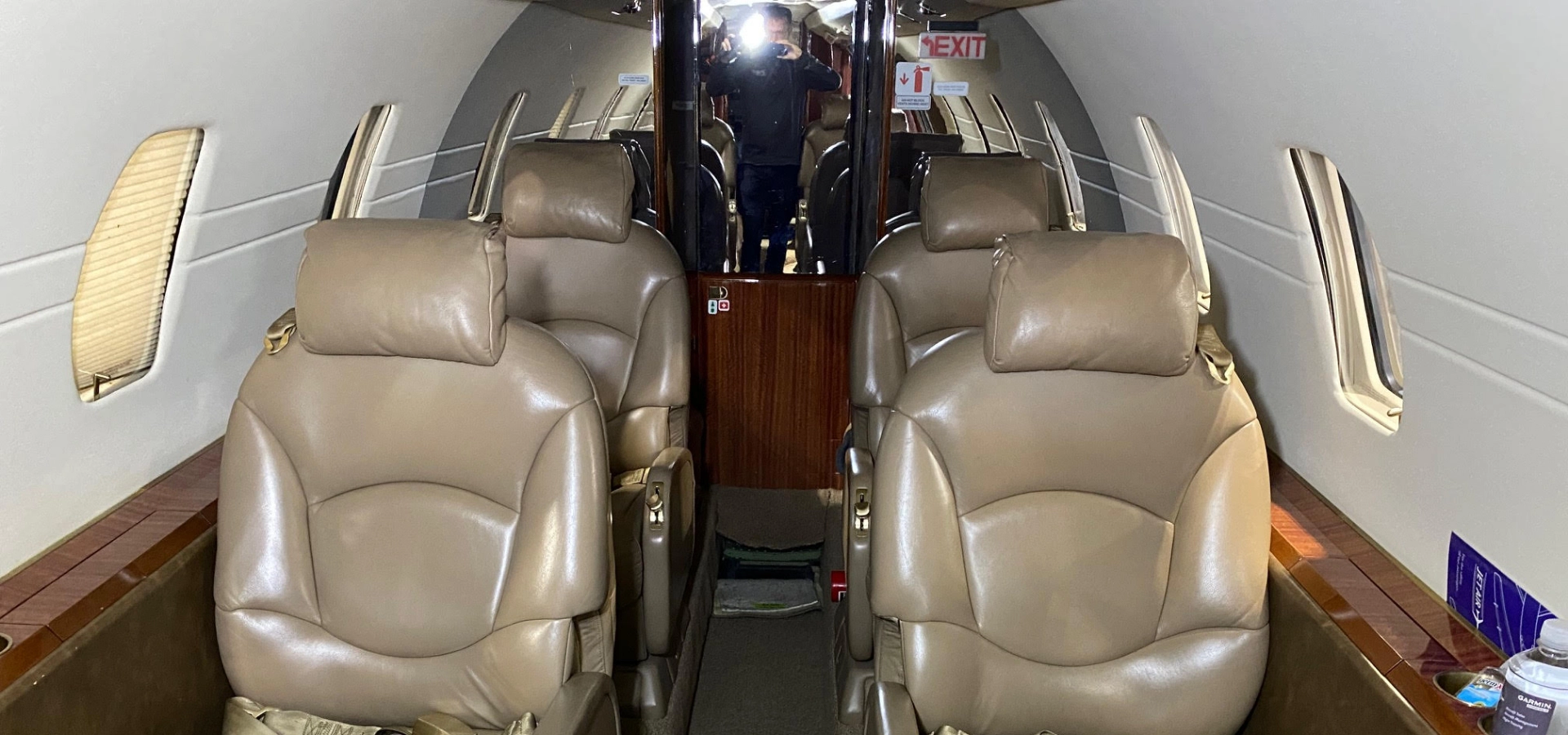 The interior of this luxurious jet features beige leather seats, arranged in two rows along the cabin aisle.