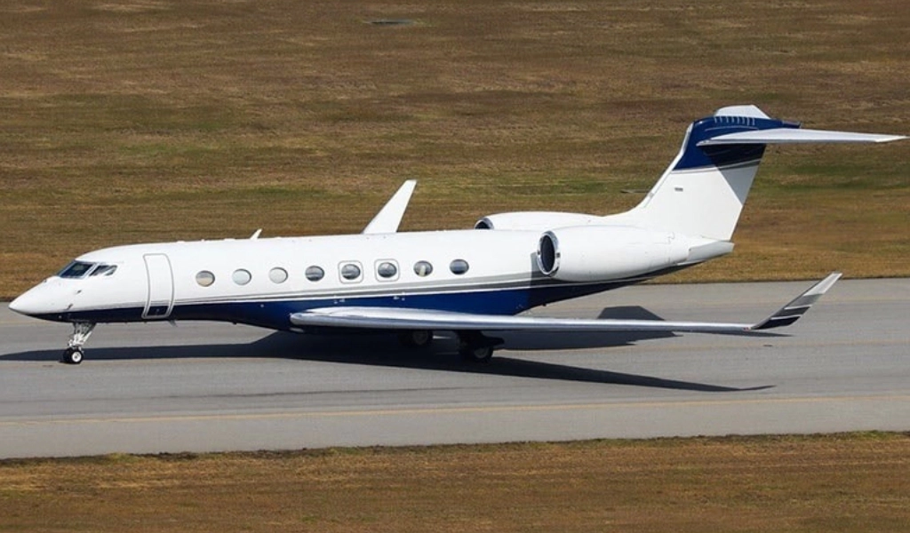 A sleek white and blue corporate jet, recently acquired through expert aircraft acquisition, is gracefully taxiing on the runway.
