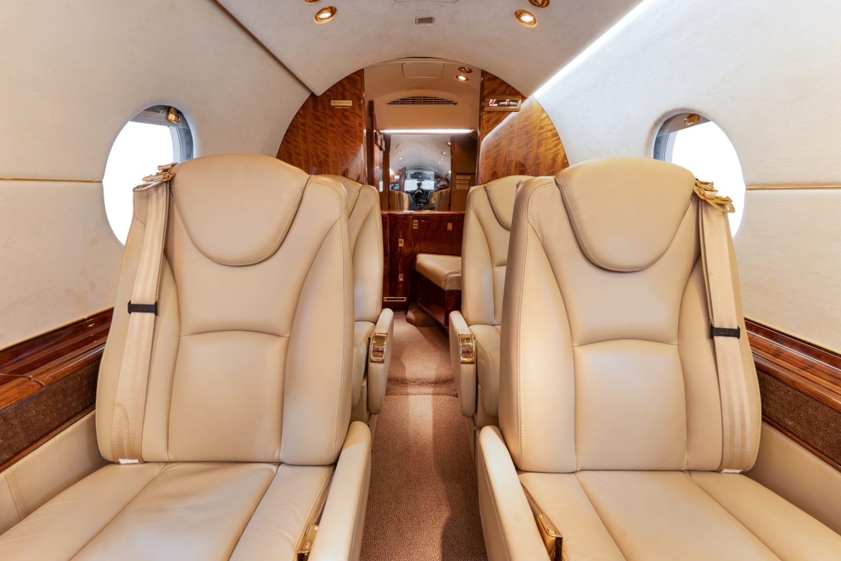 The interior of a private jet exudes elegance with beige leather seats.